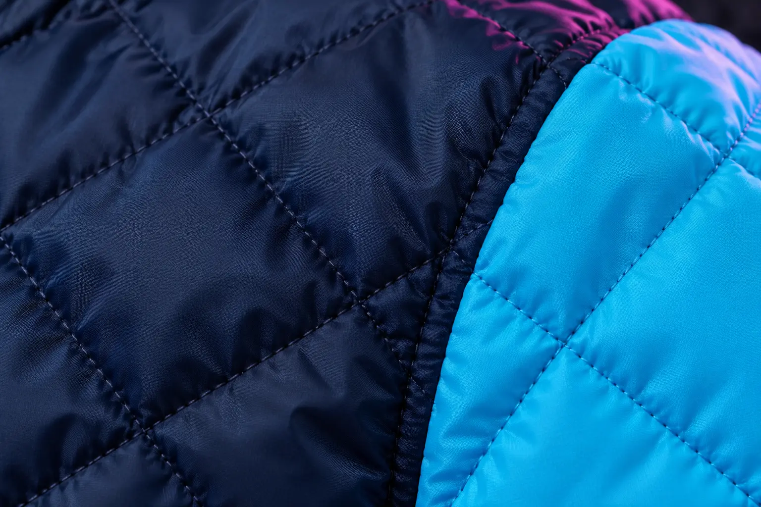 Makroaufnahme des Jackenstoffs: rautenförmig gesteppter Nylon in Navy.